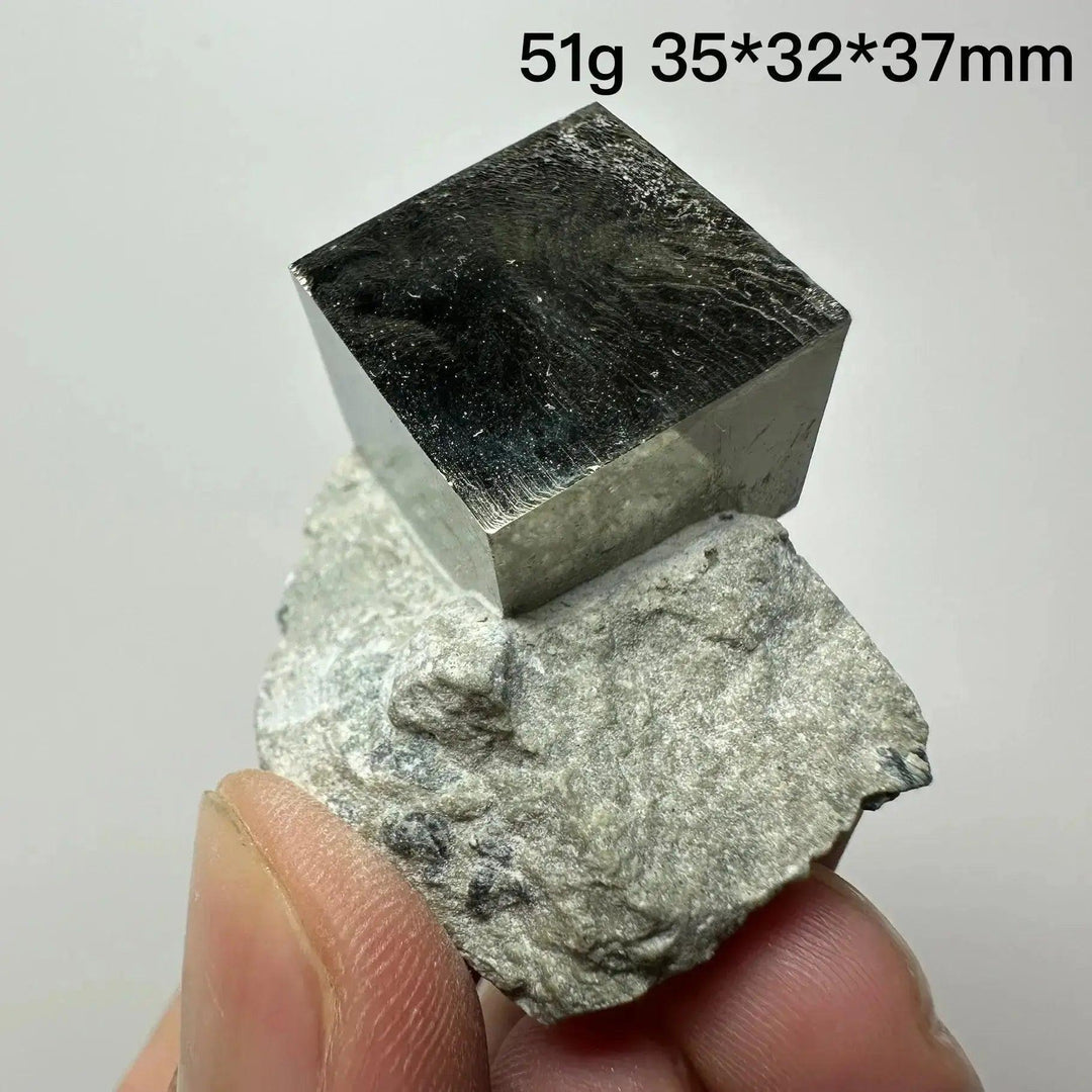 Metallic gold Pyrite Cube Crystal Specimen from Crystal Destiny, naturally formed on a light gray matrix.