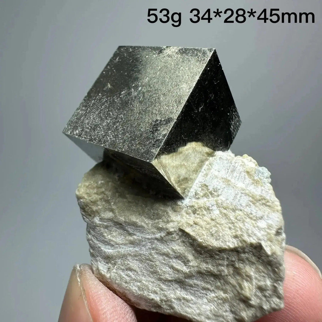 Metallic gold Pyrite Cube Crystal Specimen from Crystal Destiny, naturally formed on a light-colored matrix.