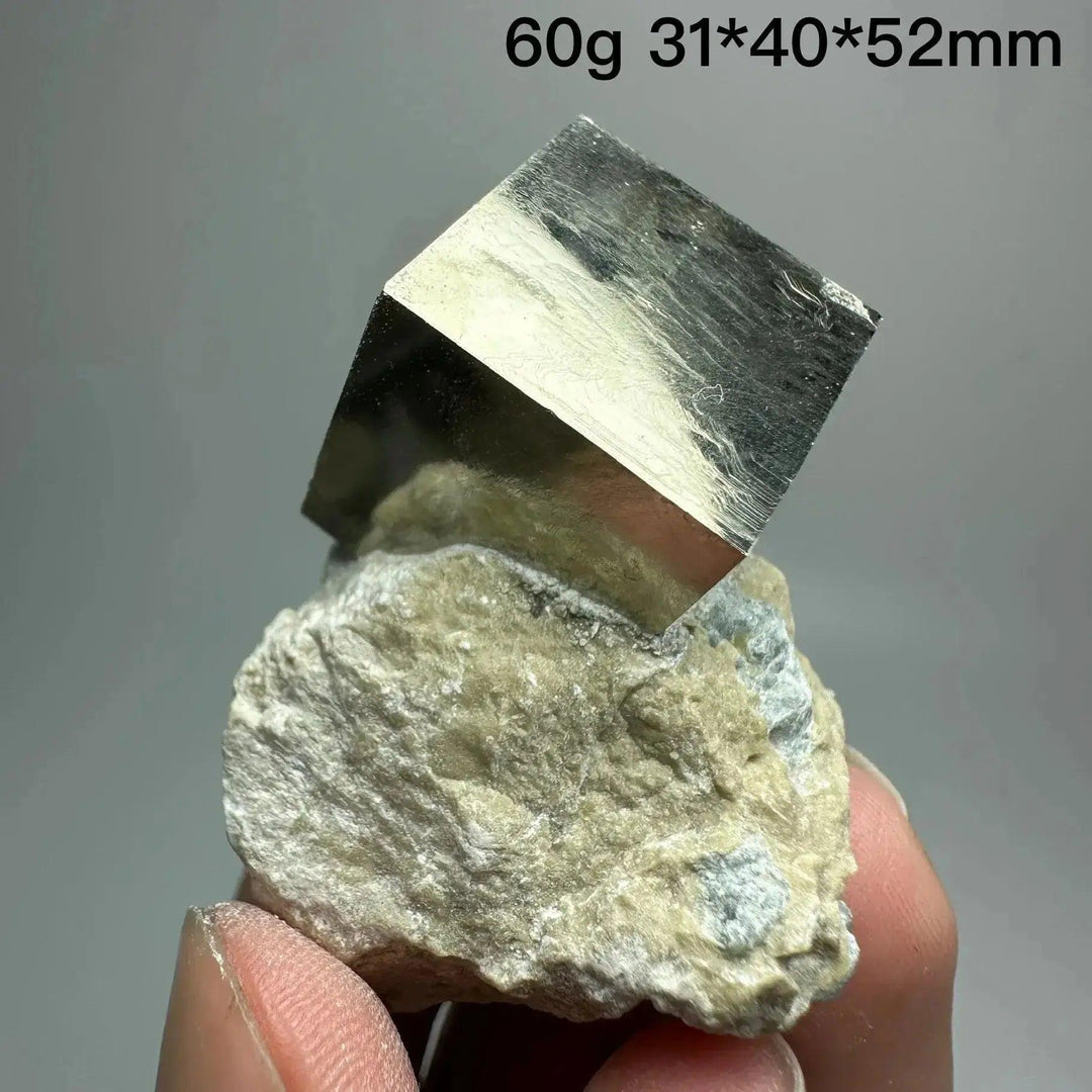 Metallic gold Pyrite Cube Crystal Specimen from Crystal Destiny, naturally formed on a light-colored matrix.