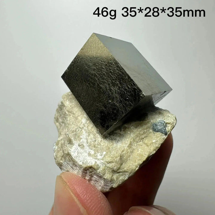 Metallic gold Pyrite Cube Crystal Specimen from Crystal Destiny, naturally formed on a light-colored matrix.