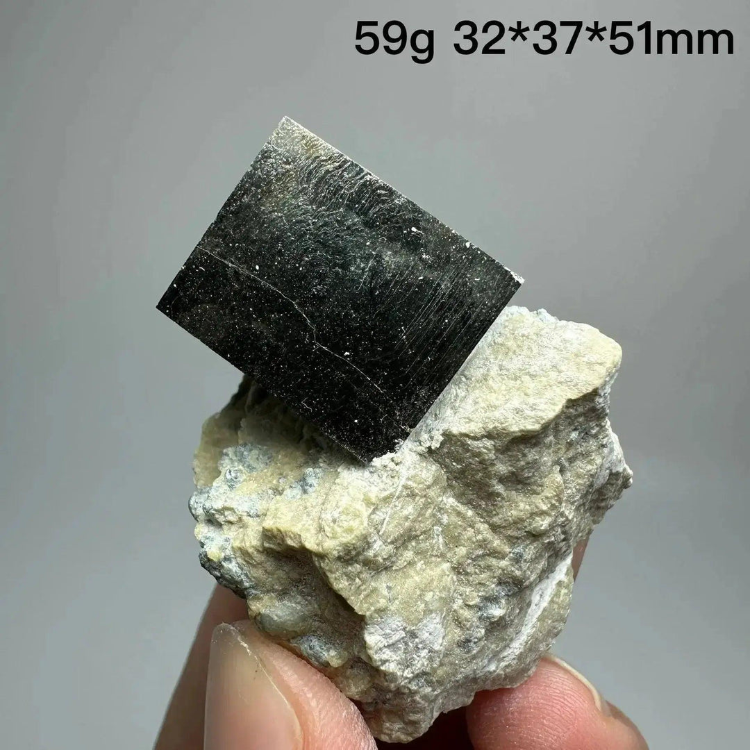 Metallic gold Pyrite Cube Crystal Specimen from Crystal Destiny, naturally formed on a light-colored matrix.