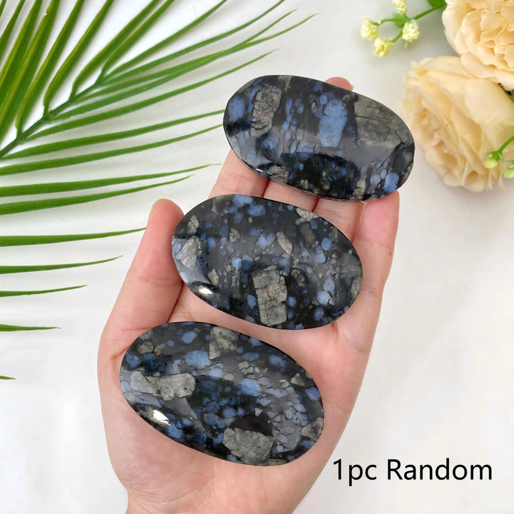 Polished Que Sera stone oval palm stones with blue and grey flecks for healing and home decor.
