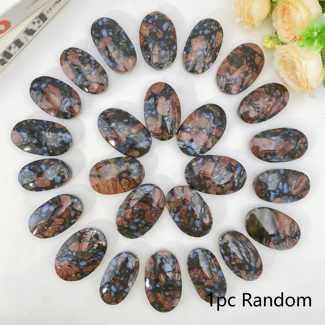Polished oval Que Sera palm stones with unique blue and brown patterns for healing and home decor.