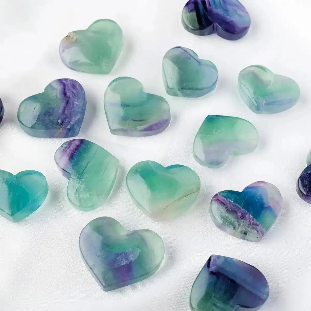 Polished Rainbow Fluorite crystal hearts in various sizes, showcasing purple, green, blue hues from Crystal Destiny.