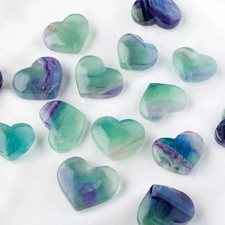 Polished Rainbow Fluorite crystal hearts in various sizes, showcasing purple, green, blue hues from Crystal Destiny.