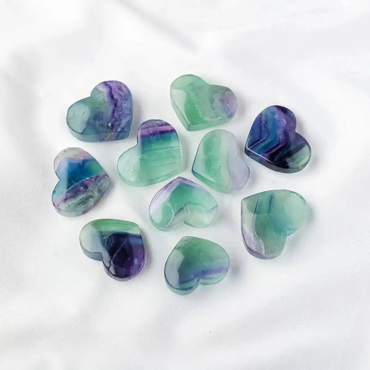 Crystal Destiny's polished Rainbow Fluorite crystal hearts, showcasing vibrant purple, green, and blue bands.