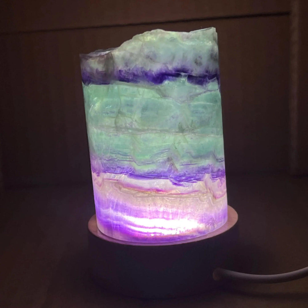 Rainbow Fluorite Crystal Light Lamp with mesmerizing purple, green, and clear bands, illuminated for a soft, ambient glow.