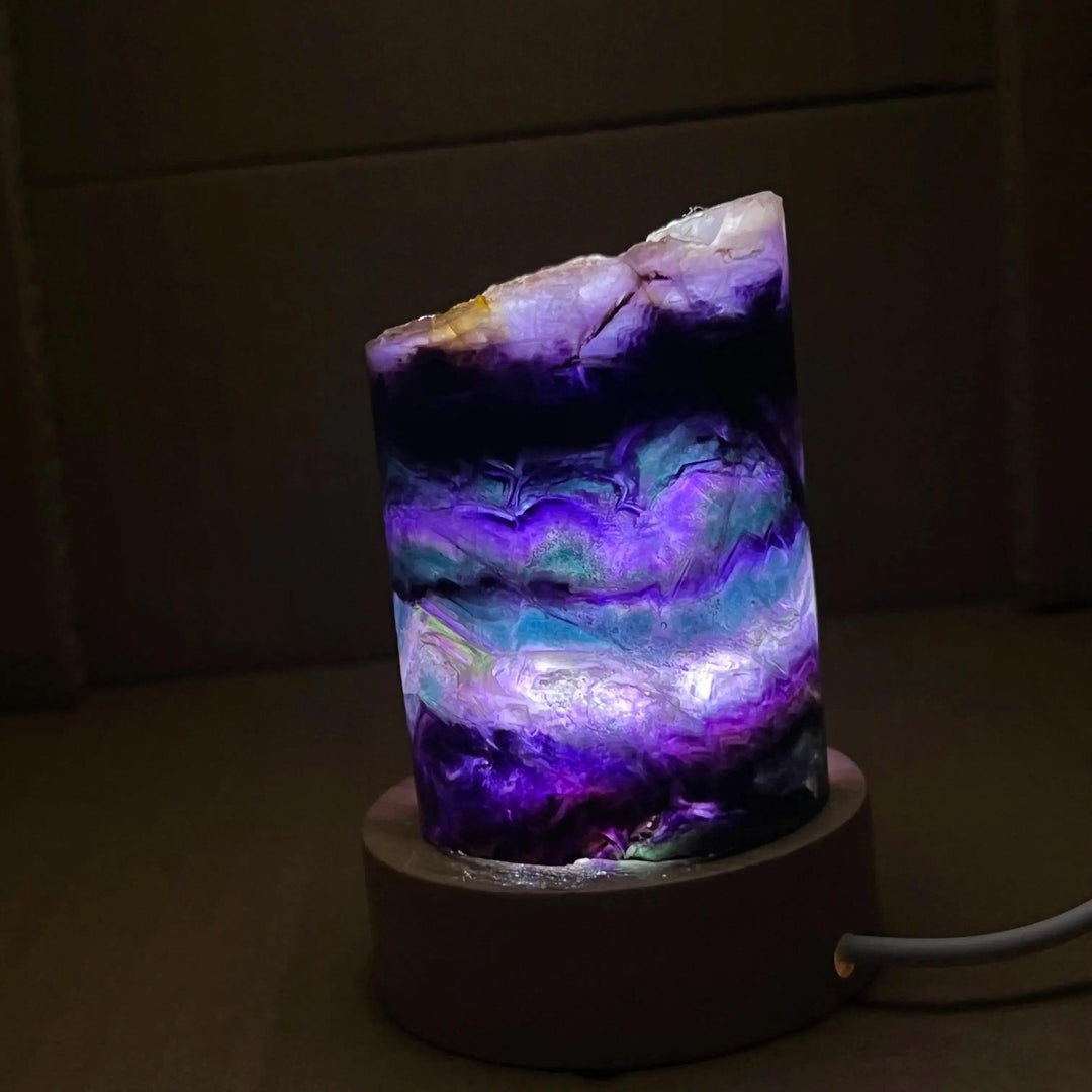 Stunning Rainbow Fluorite Crystal Light Lamp with mesmerizing purple, green, and blue bands, illuminated for a calming glow.
