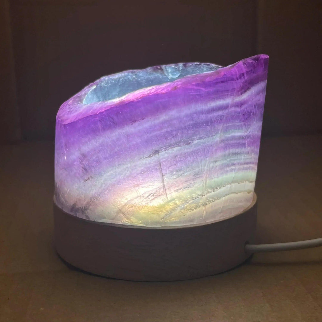 Stunning Rainbow Fluorite Crystal Light Lamp with mesmerizing purple, green, and clear bands, illuminated for a soft glow.