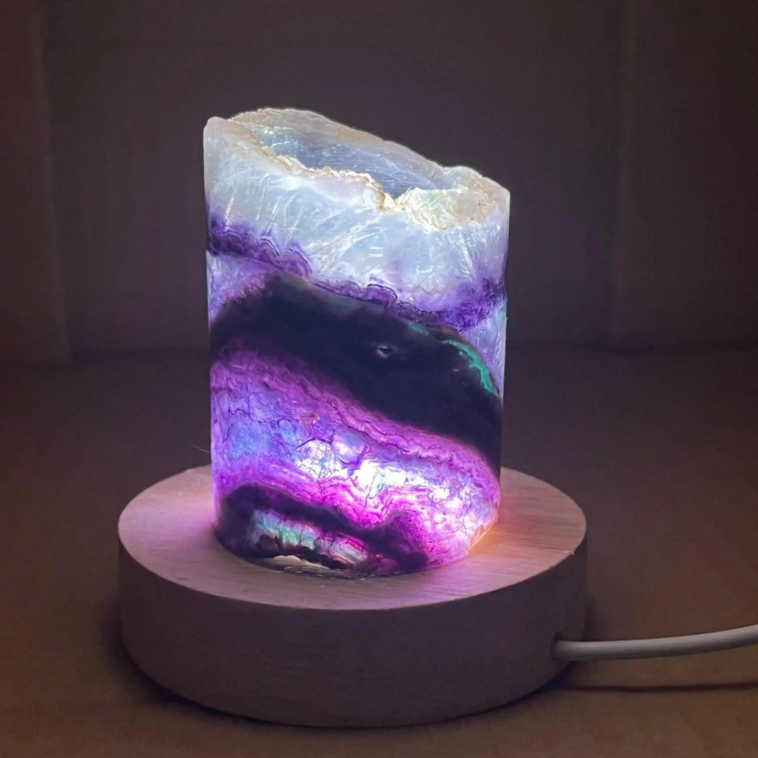 Rainbow Fluorite Crystal Light Lamp with glowing purple, green, and clear bands on a wooden base.