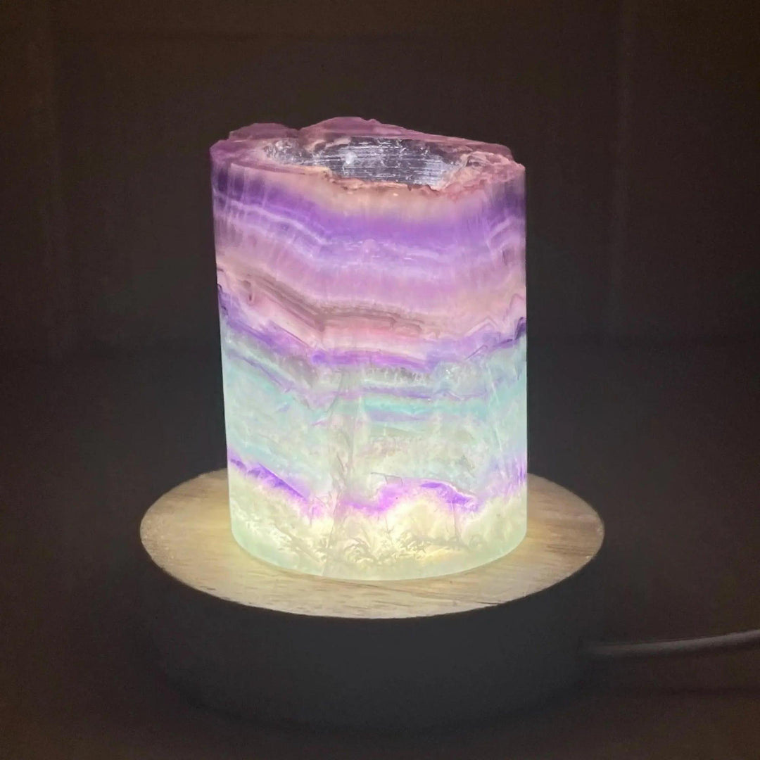 Stunning Rainbow Fluorite Crystal Light Lamp with mesmerizing bands of purple, green, and blue, illuminated for a calming glow.