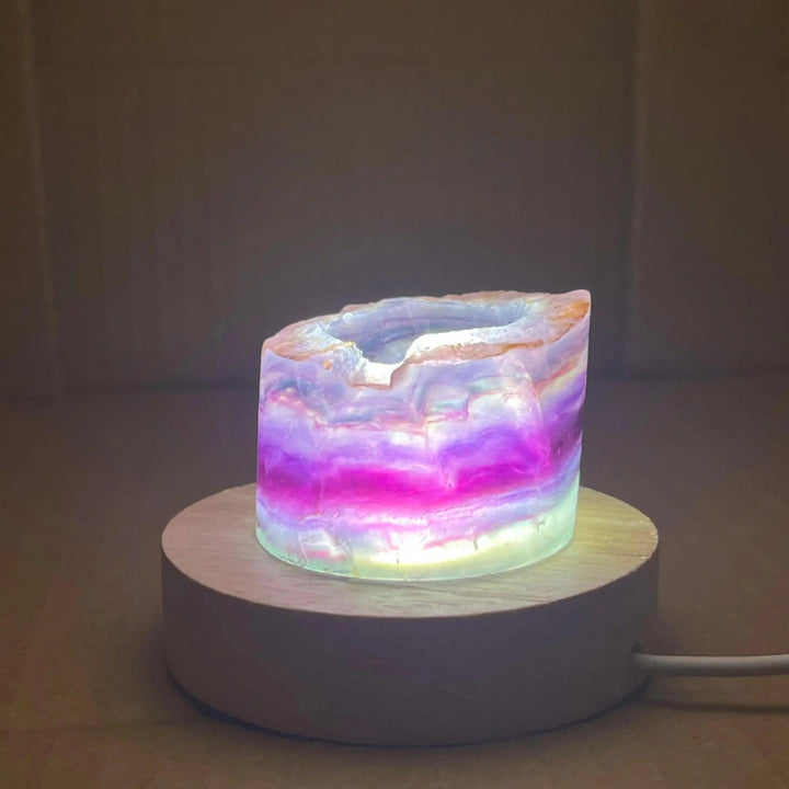 Rainbow Fluorite Crystal Light Lamp: Mesmerizing purple, green, and clear fluorite stone illuminated on a wood base.