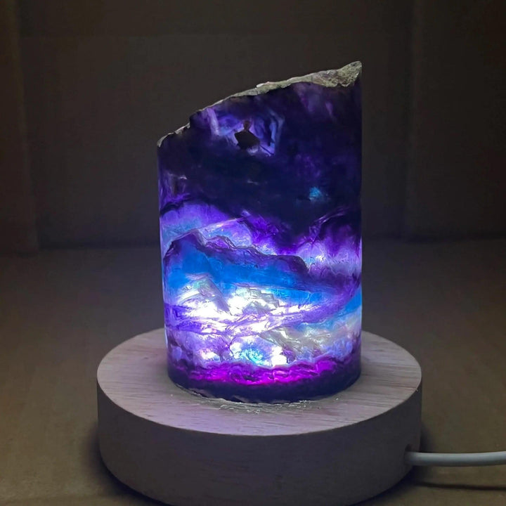Stunning Rainbow Fluorite Crystal Light Lamp with mesmerizing purple, blue, and clear bands, illuminated for a soft glow.
