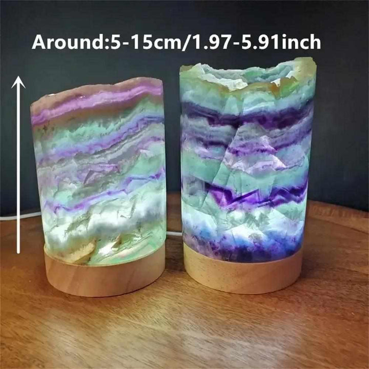 Polished rainbow fluorite crystal lamps with vibrant purple and green banding on wooden bases for meditation and decor.