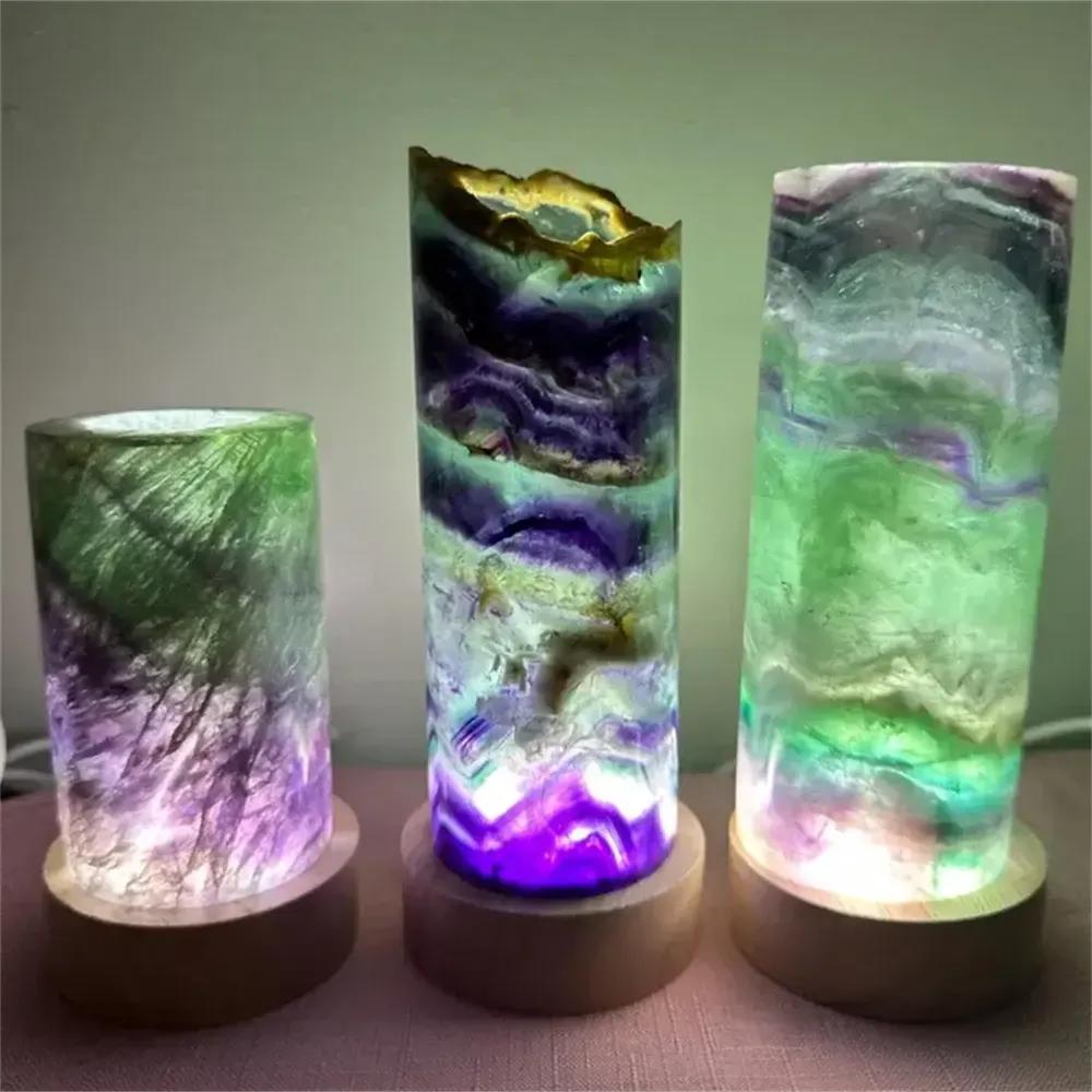 Polished rainbow fluorite crystal lamps with vibrant purple and green banding on wooden bases for meditation and decor.