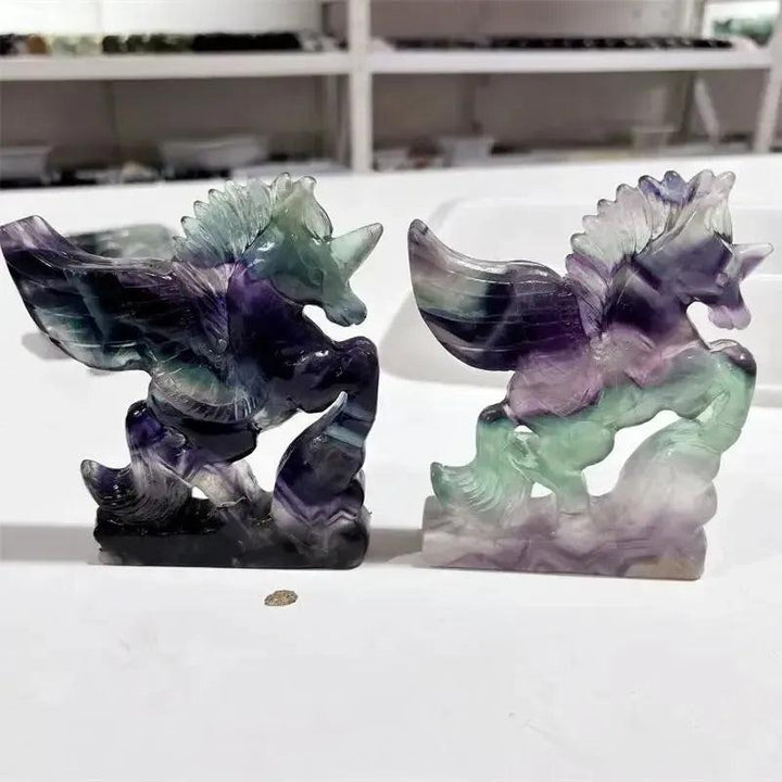 Rainbow Fluorite Unicorn Carving from Crystal Destiny, showcasing purple, green, and blue hues.