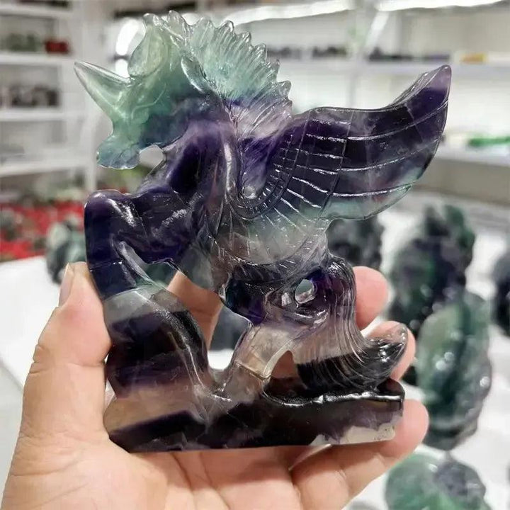 Rainbow Fluorite Unicorn Carving by Crystal Destiny, showcasing purple, green, and blue hues.