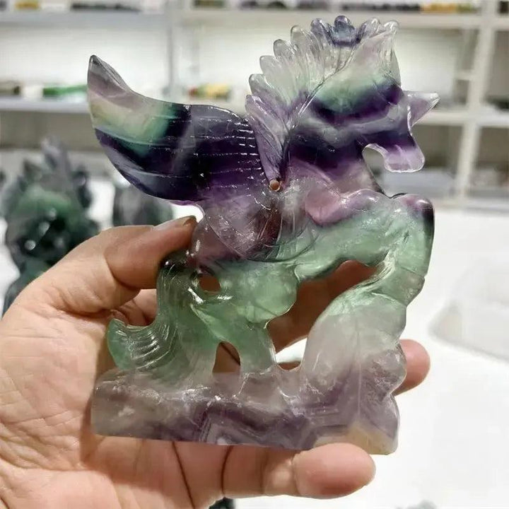 Rainbow Fluorite Unicorn Carving from Crystal Destiny, showcasing purple, green, and clear bands for clarity and magic.