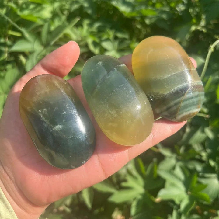 Polished rainbow mango fluorite palm stones in yellow and green hues for healing.