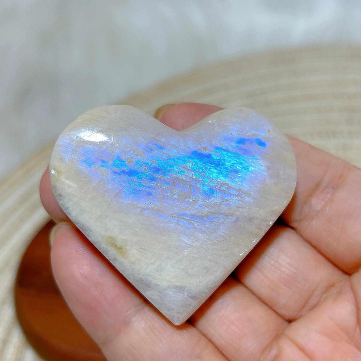 Polished Rainbow Moonstone and Sunstone heart featuring milky white tones and a vibrant blue flash for chakra balance.