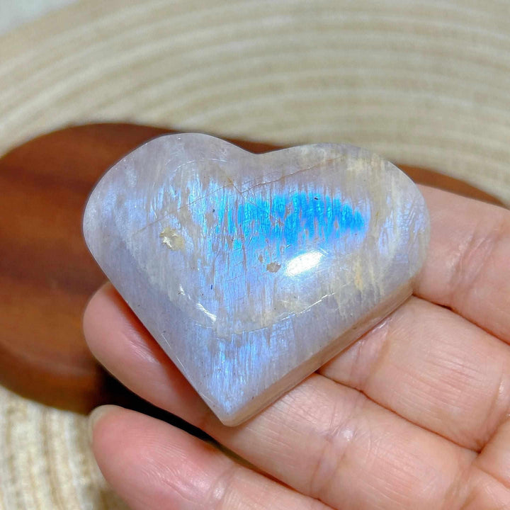 Polished Rainbow Moonstone and Sunstone heart featuring milky white tones, warm orange hues, and a vibrant blue flash.