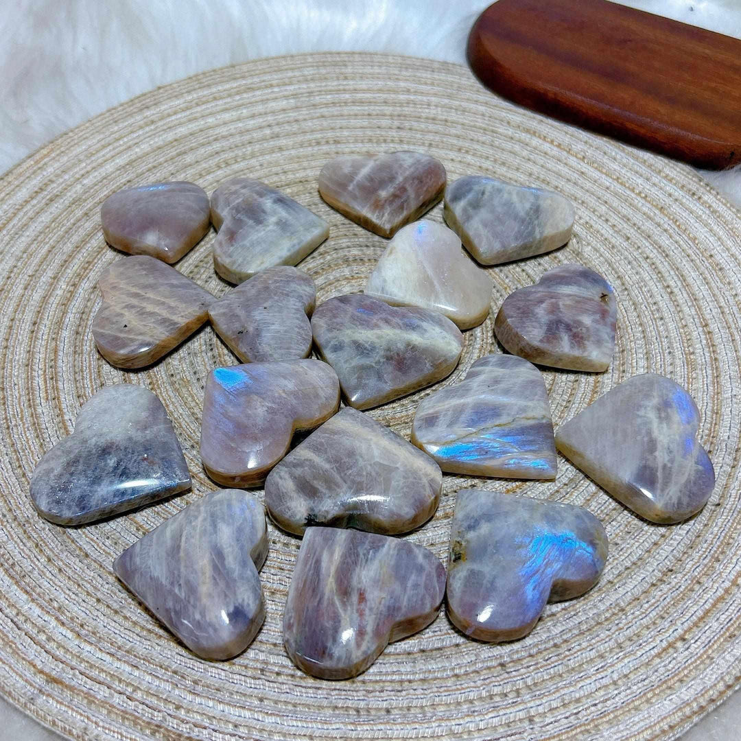 Polished Rainbow Moonstone and Sunstone hearts featuring milky white and orange tones with shimmering blue flashes.