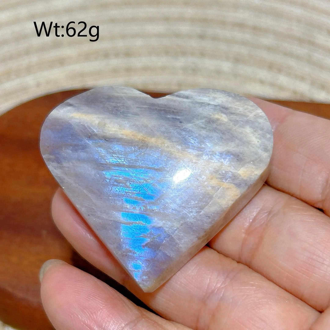 Polished Rainbow Moonstone and Sunstone heart featuring a vibrant blue flash and warm orange glow, weighing 62g.