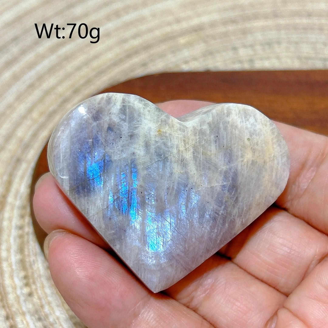 Polished 70g Rainbow Moonstone and Sunstone heart featuring milky white tones, warm orange hues, and vibrant blue flash.