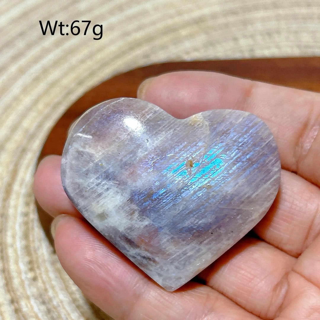 Polished Rainbow Moonstone and Sunstone heart with milky white tones, orange warmth, and a vibrant blue flash. 67g weight.