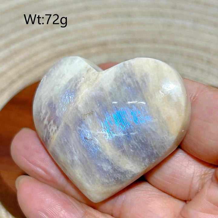 Polished Rainbow Moonstone and Sunstone heart with milky white tones, warm orange hues, and a vibrant blue flash.