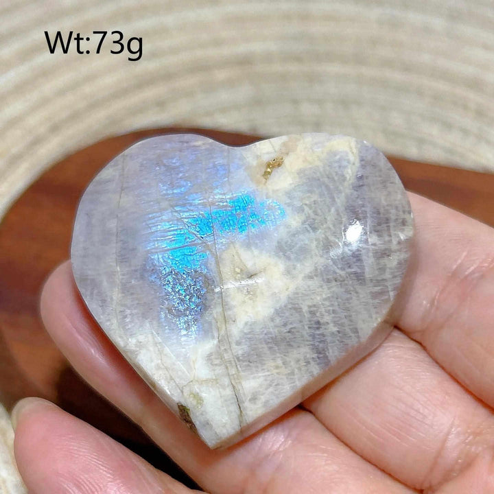 Polished 73g Rainbow Moonstone and Sunstone heart featuring a milky white surface with vibrant blue flash and sparkle.