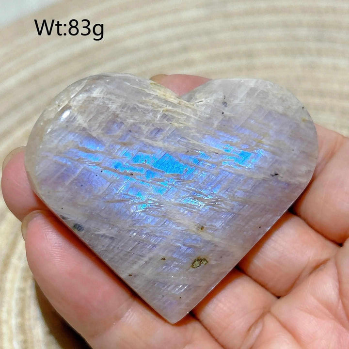 Polished 83g Rainbow Moonstone and Sunstone heart featuring a milky white surface with vibrant blue flashes and sparkle.