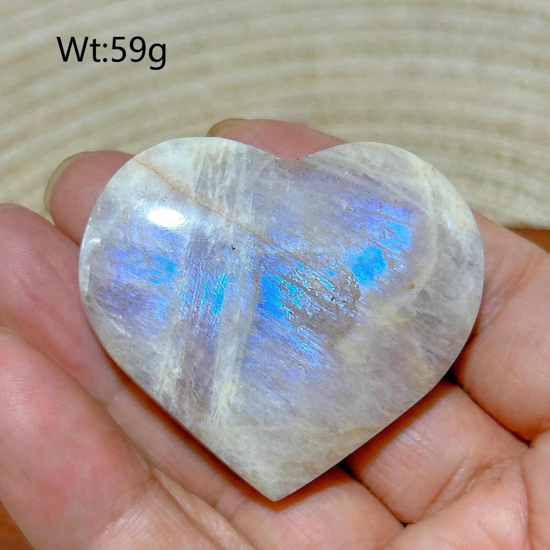 Polished 59g Rainbow Moonstone and Sunstone heart featuring milky white tones and vibrant blue flashes for chakra healing.
