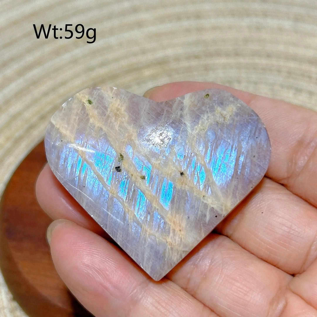 Polished Rainbow Moonstone and Sunstone heart featuring milky white tones, warm orange veins, and vibrant blue flash.