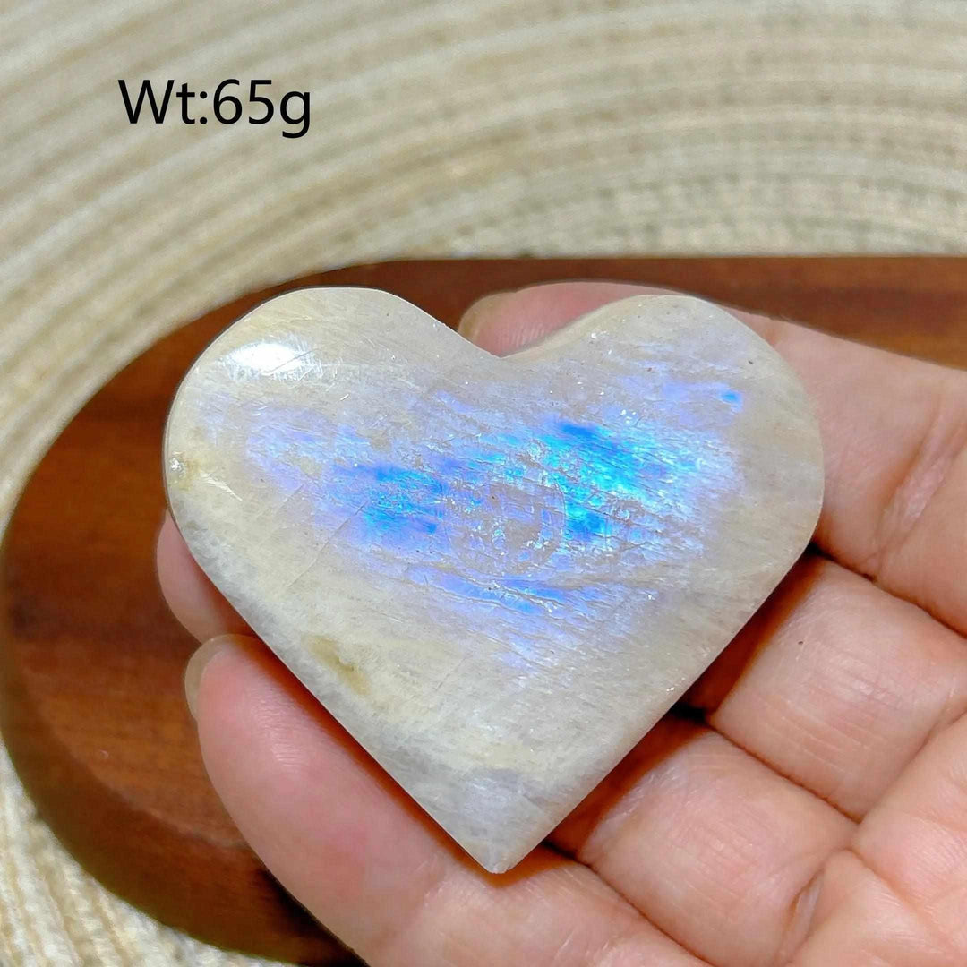 Polished 65g Rainbow Moonstone and Sunstone heart featuring milky white tones and a vibrant blue flash for chakra balance.