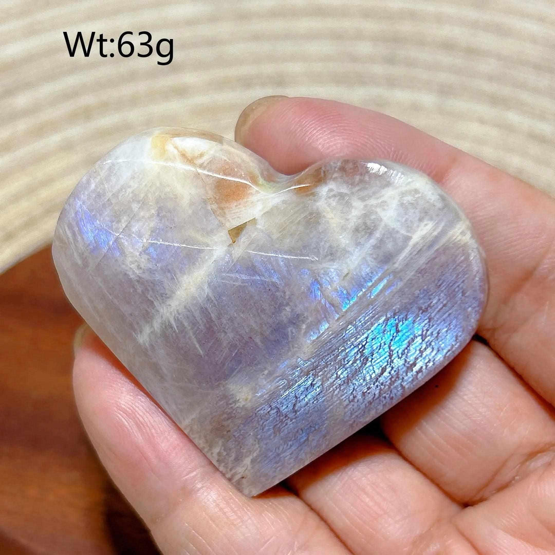 Polished Rainbow Moonstone and Sunstone heart featuring milky white tones, warm orange flashes, and intuitive energy.