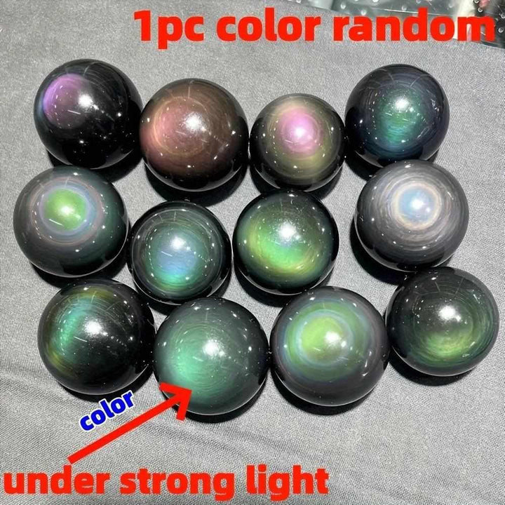 Polished Rainbow Obsidian spheres showing vibrant, iridescent color bands under light for root chakra protection.