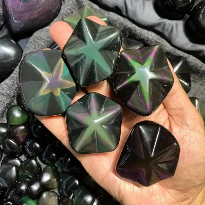 Hand-carved rainbow obsidian star with shimmering purple, green, and gold flashes for grounding and protection.