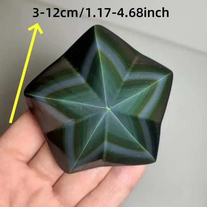 Hand-carved Rainbow Obsidian star with a polished black finish and vibrant green, purple, and gold light-reflecting bands.