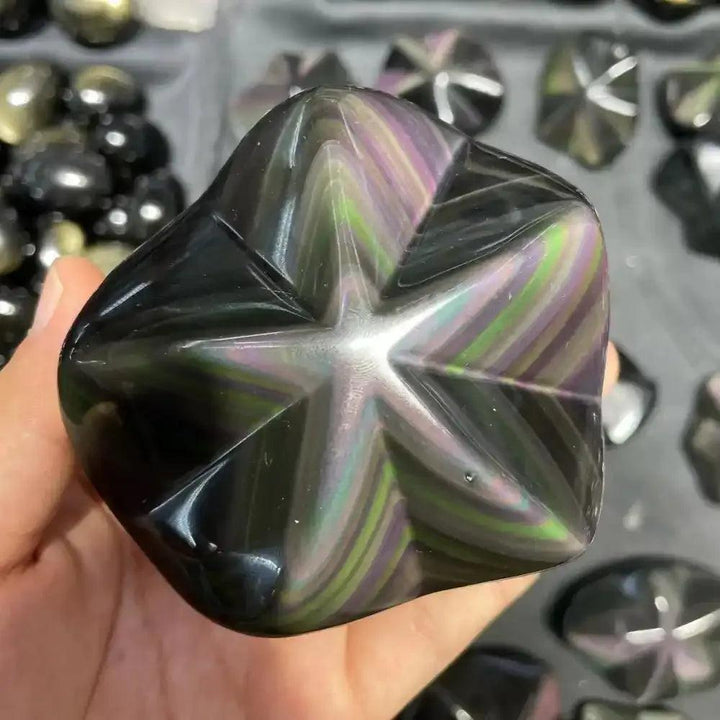 Hand-carved Rainbow Obsidian star with a polished black surface and shimmering purple, green, and gold protective sheen.