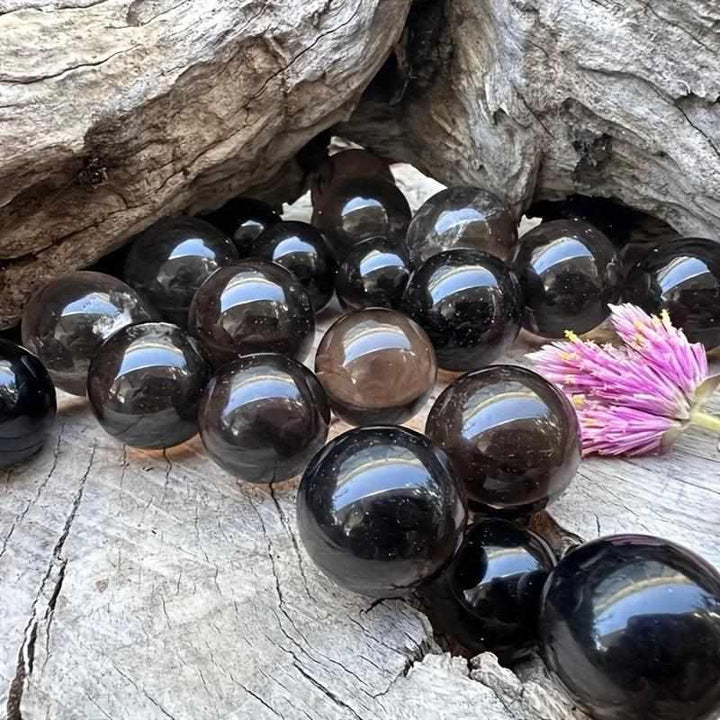Polished Rainbow Smoky Quartz spheres in brown and gray tones, perfect for grounding and root chakra healing.