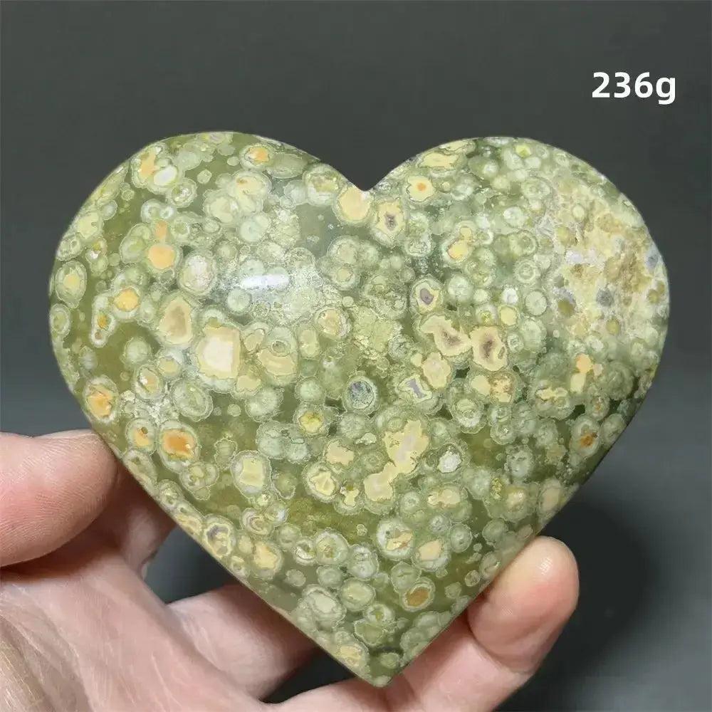 Rainforest Jasper Heart Healing Crystal: Green heart-shaped crystal with organic yellow-cream patterns, held in a hand.