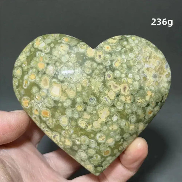 Rainforest Jasper Heart Healing Crystal: Green heart-shaped crystal with organic yellow-cream patterns, held in a hand.