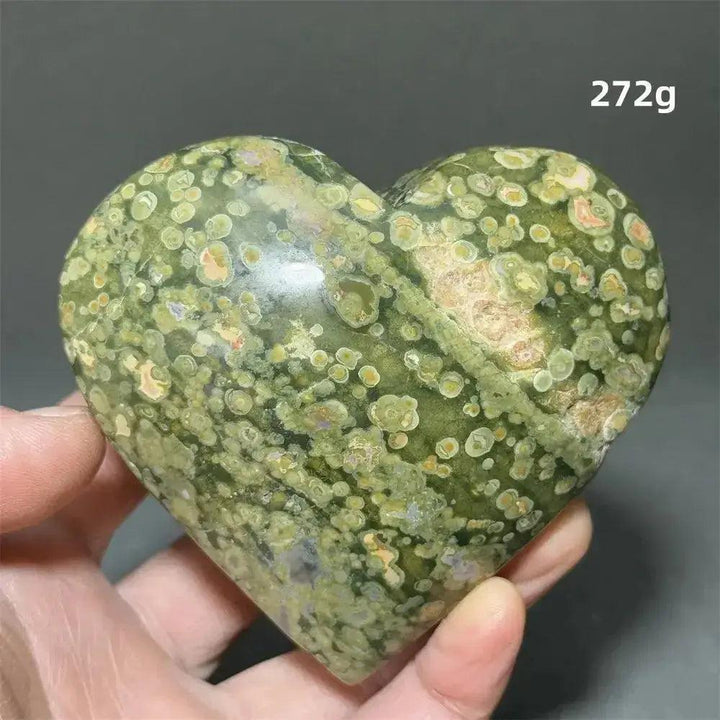 Rainforest Jasper Heart Healing Crystal: Polished green heart-shaped Rhyolite with unique organic patterns, held in a hand.