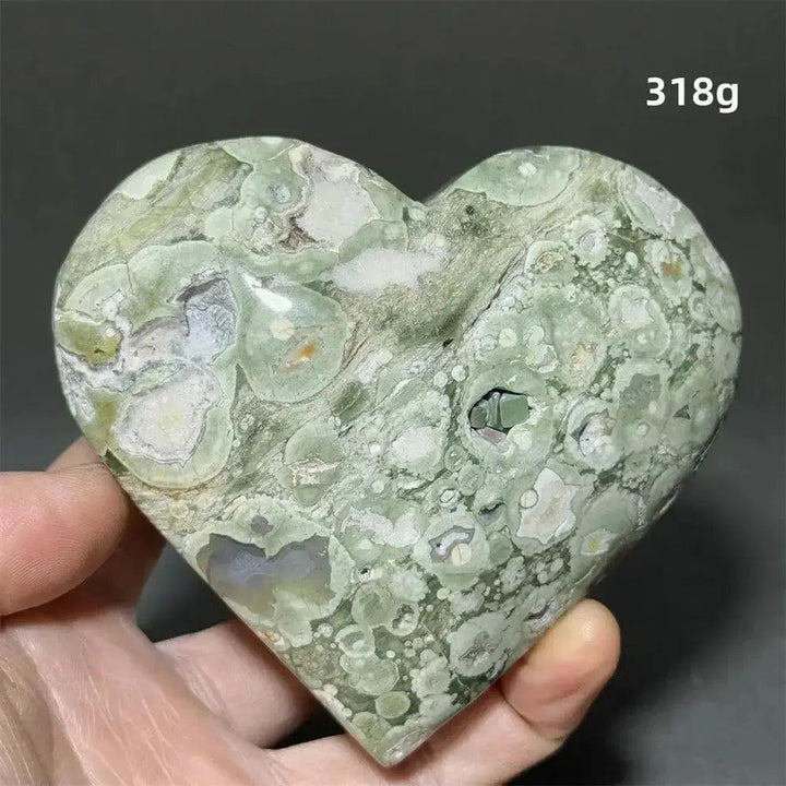 Rainforest Jasper heart healing crystal, 318g, with mottled green, white, and brown patterns, held by Crystal Destiny.