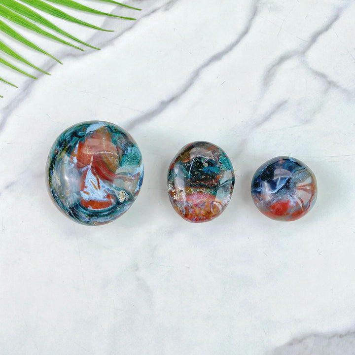 Polished Ocean Jasper palm stones featuring vibrant swirling colors, perfect for healing, meditation, and home decor.
