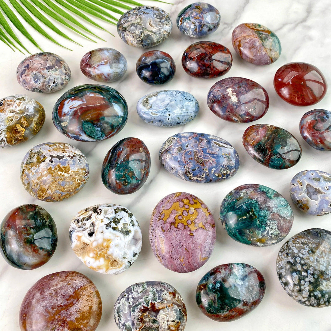 Polished Ocean Jasper palm stones featuring vibrant, natural patterns and healing energy for crystal decor and jewelry.