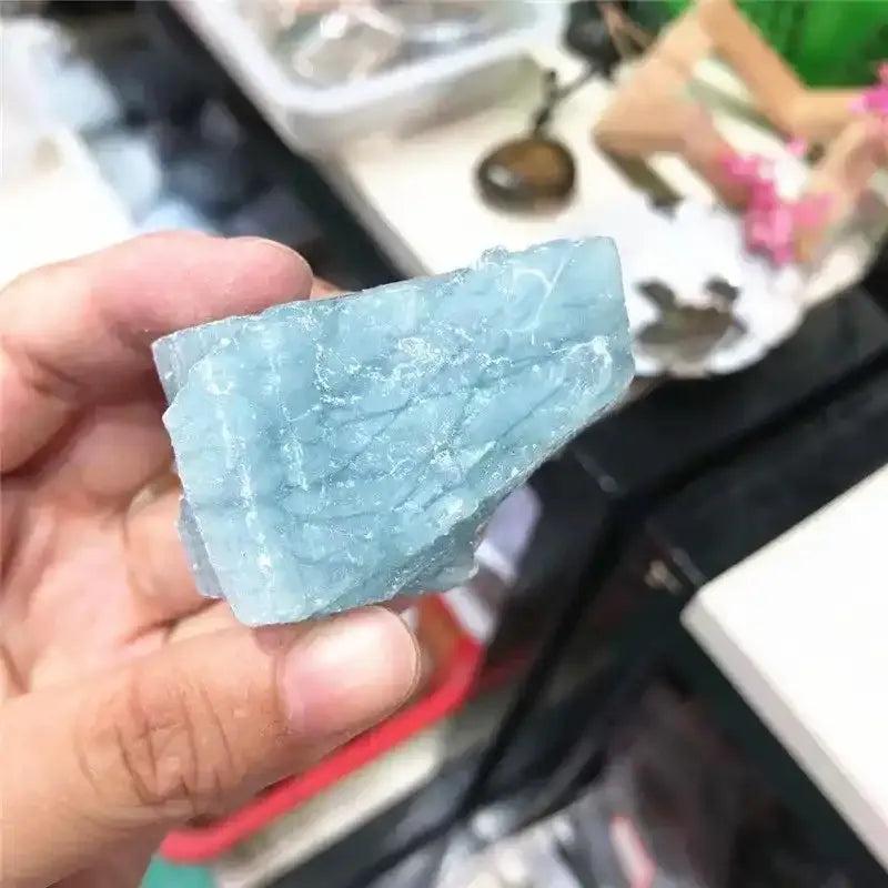 Raw aquamarine crystal with natural sea-blue color, rough unpolished texture, and calming energy for chakra healing.