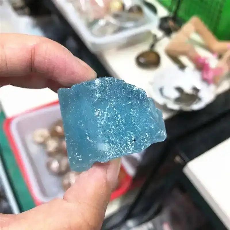 Raw aquamarine crystal with a natural sea-blue color, rough unpolished texture, and calming energy for chakra healing.