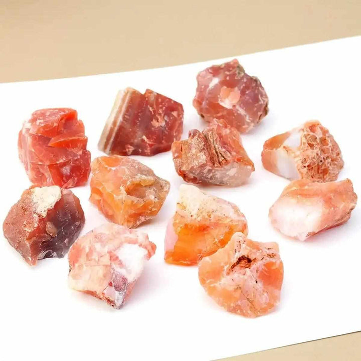 Raw carnelian stones in warm orange and red-brown hues, perfect for sacral chakra healing and creative energy.